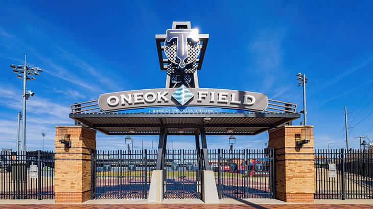 An entrance gate with a sign on top that says "Oneok Field"