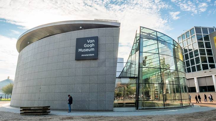 A modernist cylindrical-shaped building with a man standing in front