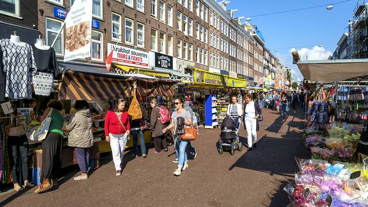 People walking on a street surrounded by market stalls