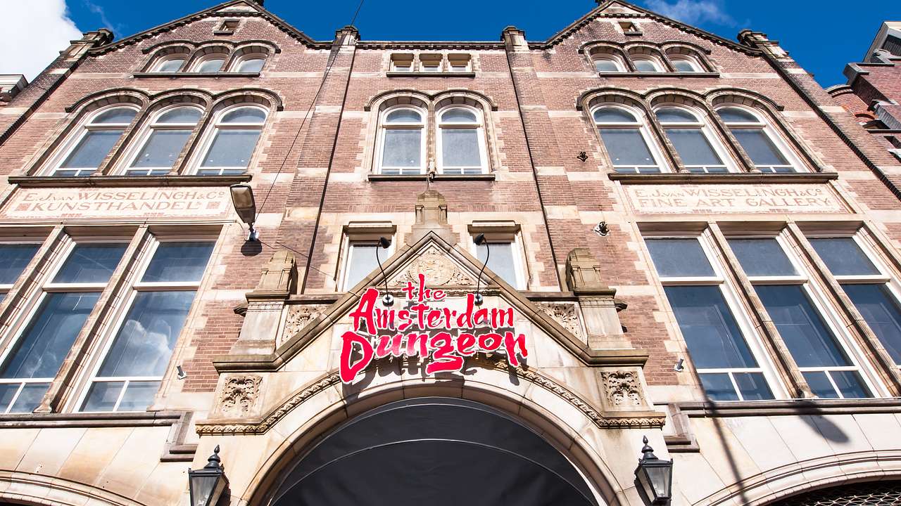 A facade of a building with many glass windows and a "The Amsterdam Dungeon" sign