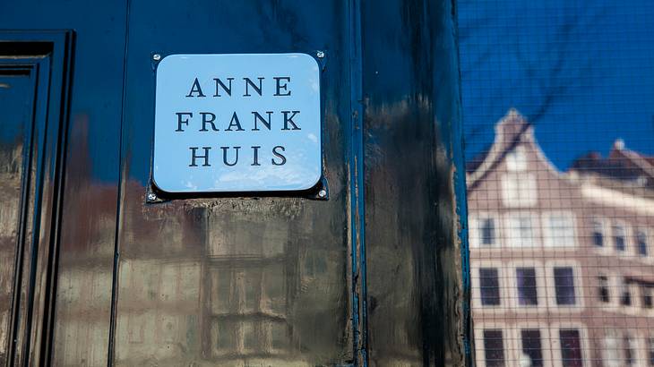 Signage on a black door that says "Anne Frank Huis"