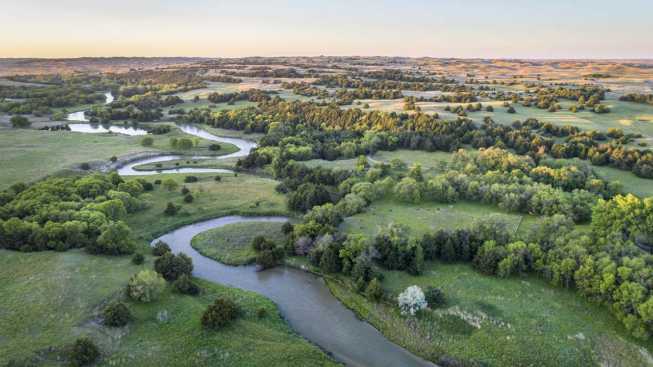 Aerial shot of a river meandering over a green valley