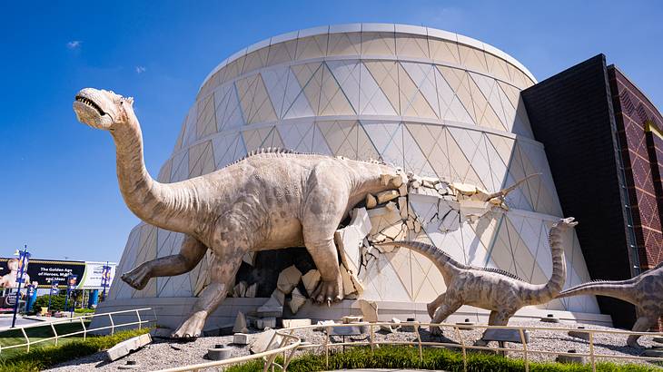 A circular building decorated with sculptures of dinosaurs