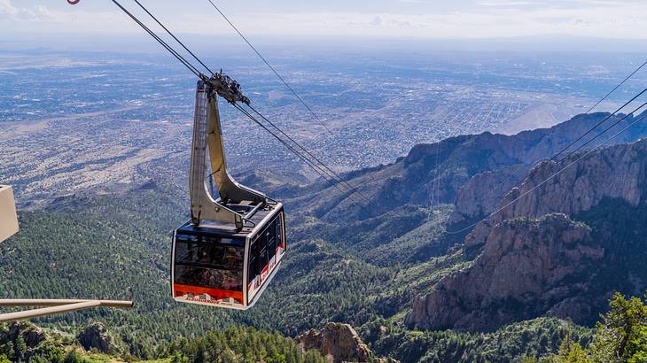 A cable car above greenery-covered mountains