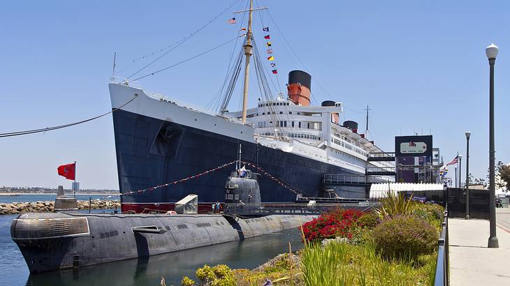 A ship and a submarine docked alongside a pier