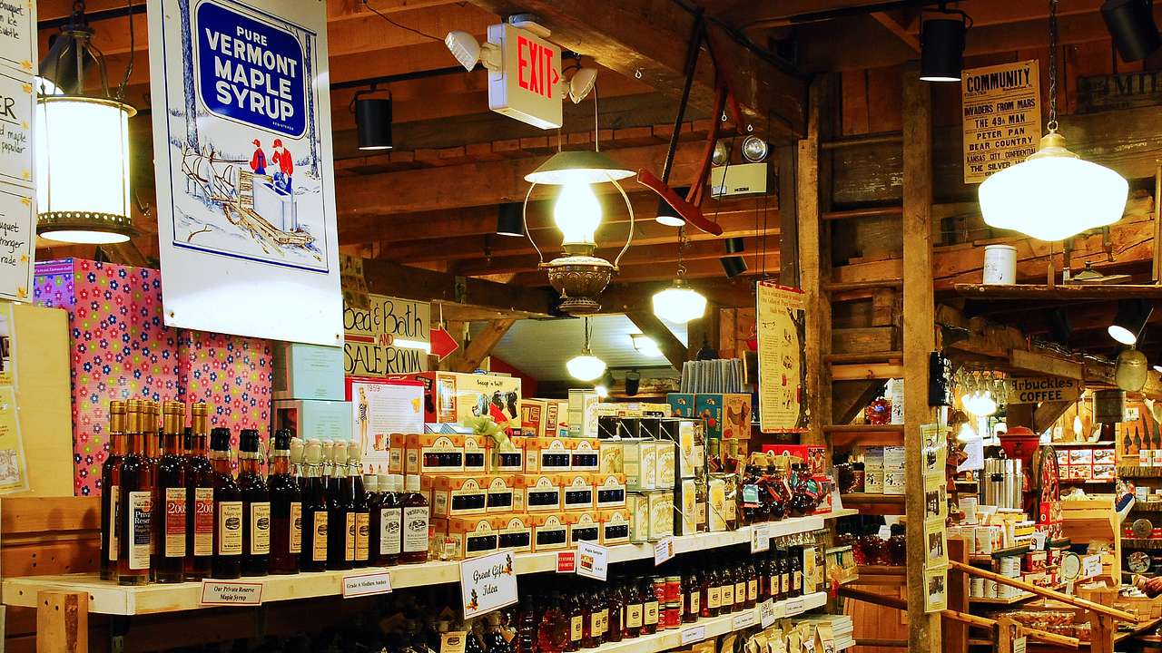 A country store with maple products on a shelf and a "Vermont Maple Syrup" sign