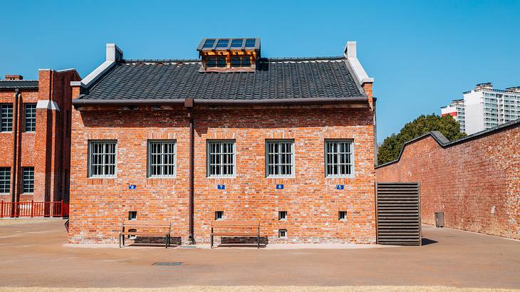 The outside of a brick museum building with 5 windows and blue sky above