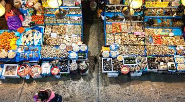 Market tables filled with an assortment of fish and seafood for sale from above