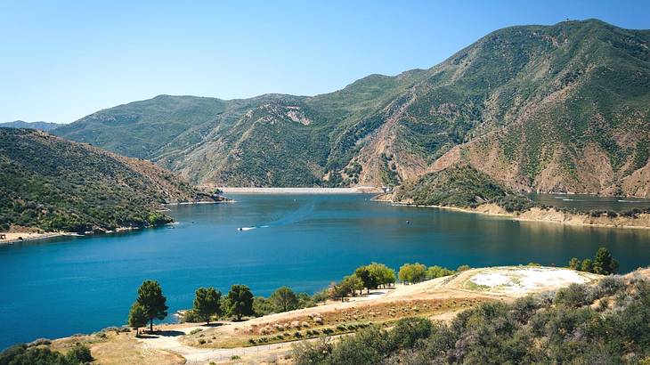 A lake with greenery-covered hills around it