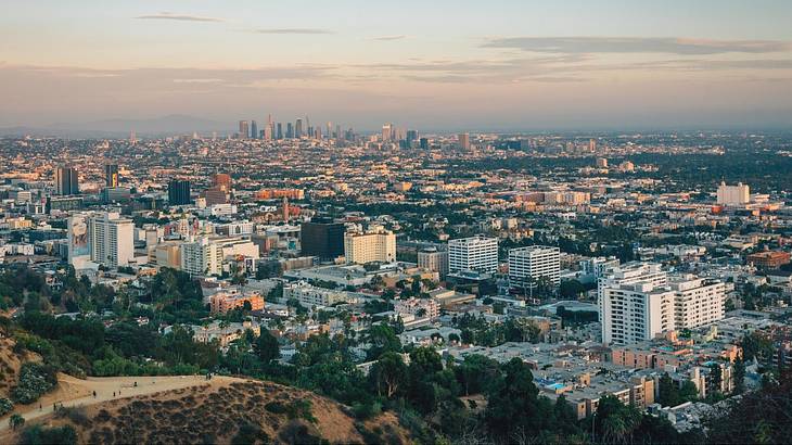 A view across a city from a hilltop at sunset