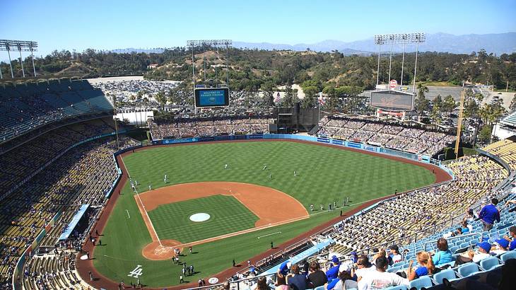 A baseball stadium with a game in play on a clear day