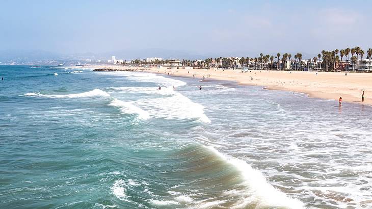 A beach with ocean waves crashing onto the sandy shore