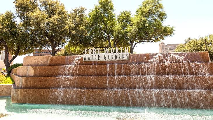 A waterfall-like feature with a "Fort Worth Water Gardens" sign