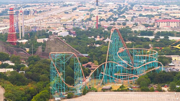 A theme park with a roller coaster and view across a town