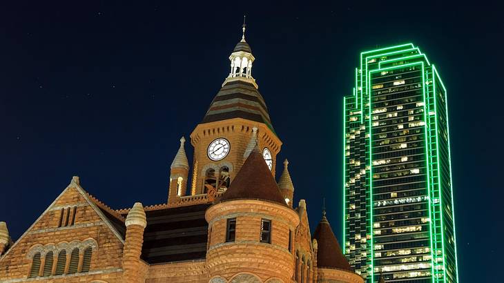 A church-like building and illuminated skyscraper at night