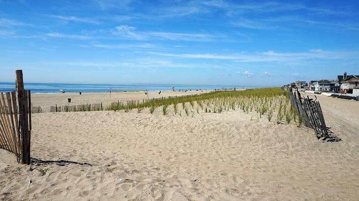 A sandy beach with a fence next to the ocean