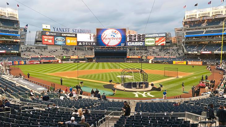 A baseball stadium with some fans in the stands under a cloudy sky