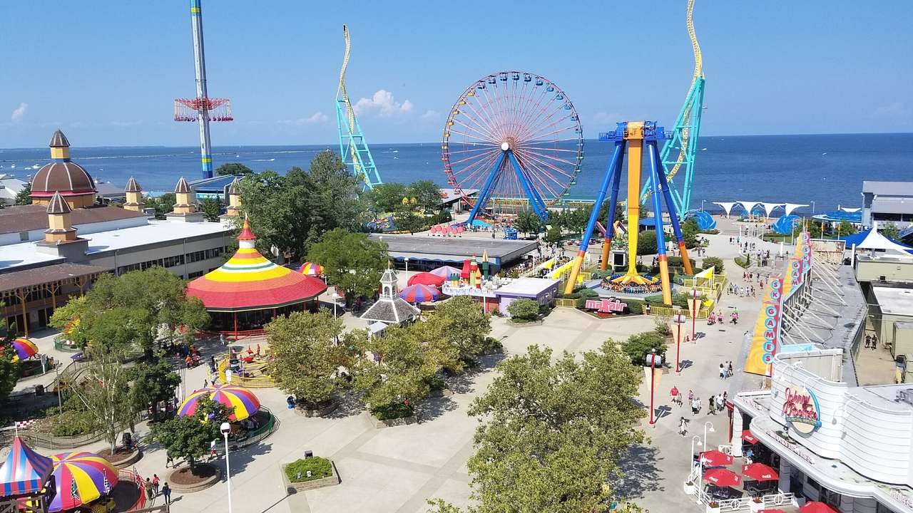 A view over a colorful amusement park next to the water on a clear day