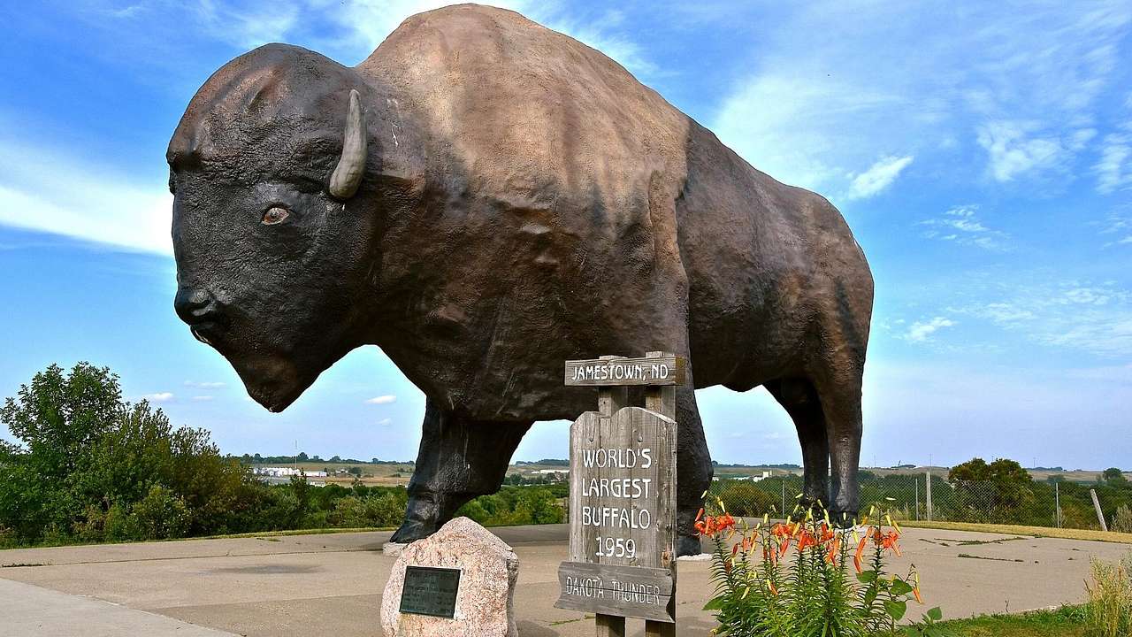 A sign of "world's largest buffalo" against a sculpture of a buffalo