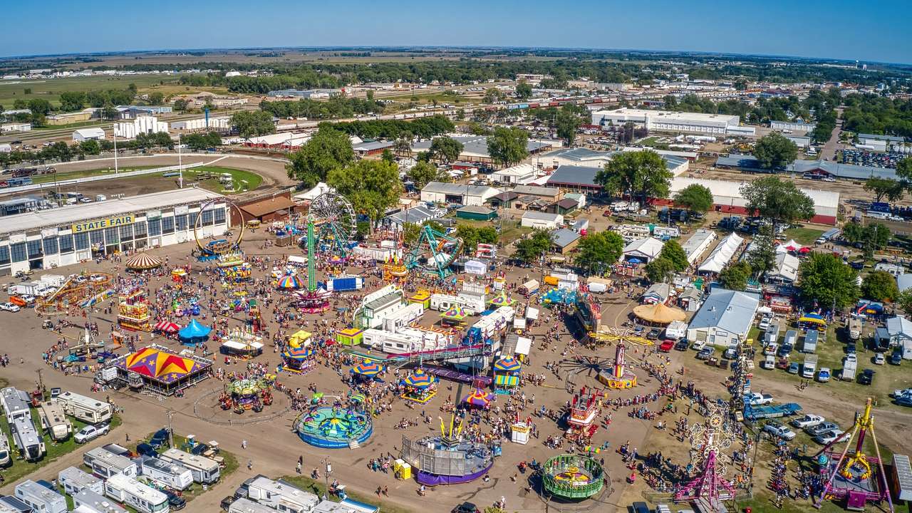 An aerial view of a state fair with colorful rides