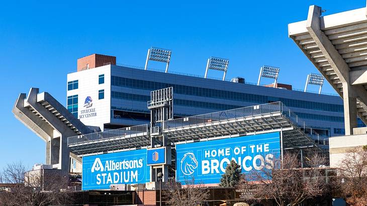 A stadium with a blue billboard of "Albertsons Stadium" and "Home of the Broncos"