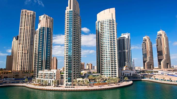 A beautiful waterfront surrounded by towering skyscrapers on a clear day A beautiful waterfront surrounded by towering skyscrapers on a clear day