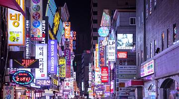 A night market filled with billboards and colourful neon lighting along buildings