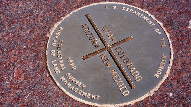 A round monument on the floor with text: New Mexico, Arizona, Colorado, and Utah