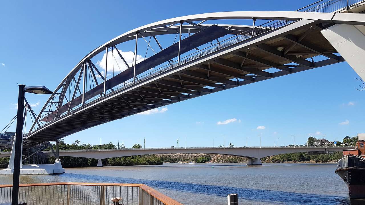 A bridge over a river with another bridge at the back and a bicycle in front