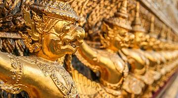 A close up of the golden buddhas etched into the side of the palace