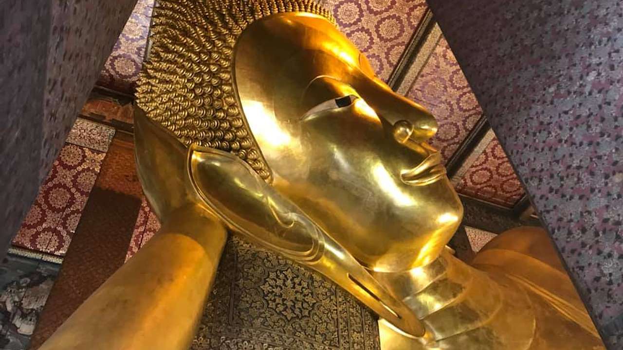 A close up of the golden head of the Reclining Buddha found in Wat Pho