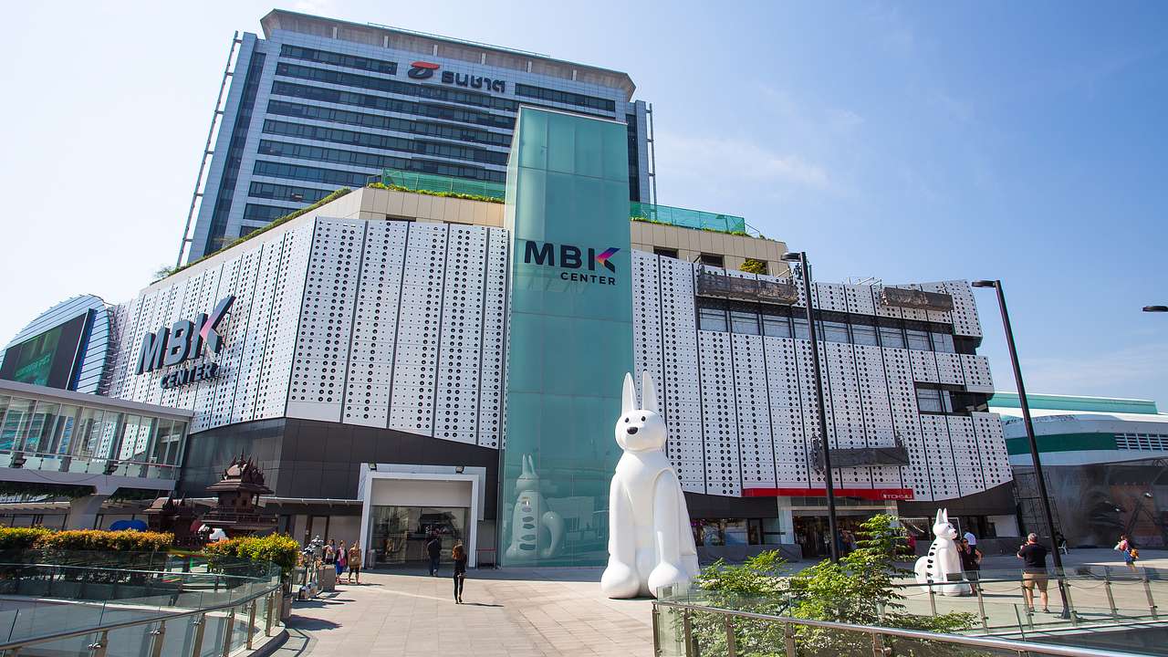 A walkway leading to a large building with a big white rabbit statue in front