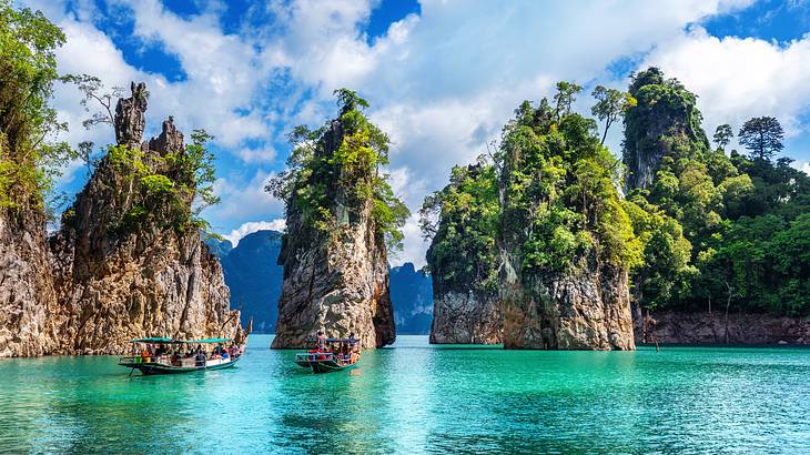 Body of water with vegetation-covered limestone cliffs in the back and boats in front