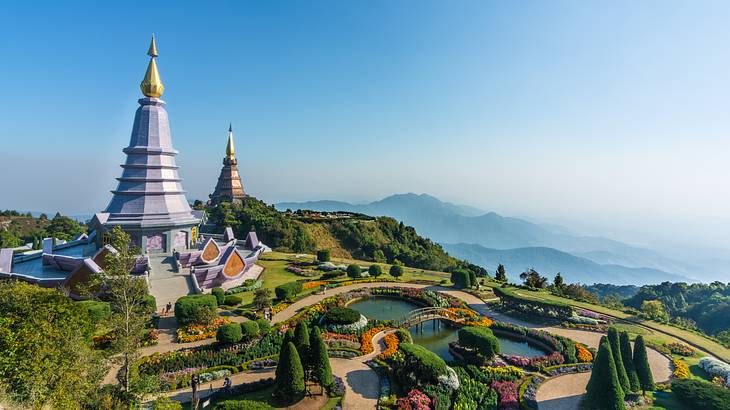 An aerial side view of a temple and the surrounding manicured gardens with a pond