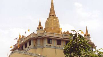 Golden Mount atop of a golden temple with a leafy tree in front