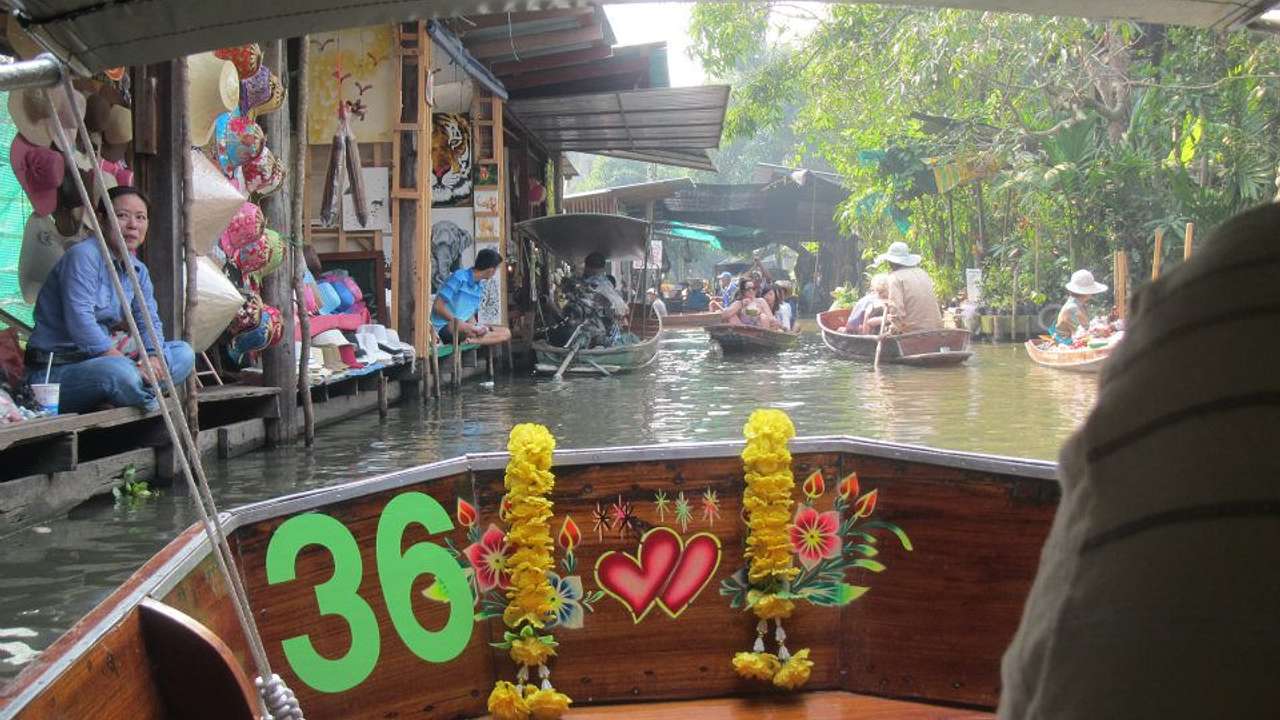 A shot of the floating market with items and people sitting from inside a boat