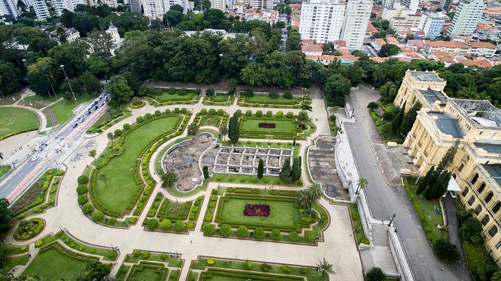 Aerial view of a large park and garden surrounded by city buildings and a road