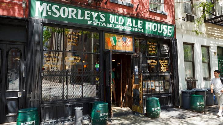 A green signboard displaying McSorley’s Old Ale House atop pub windows