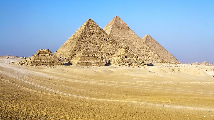 Several pyramids of varying heights in a sandy desert on a clear blue day