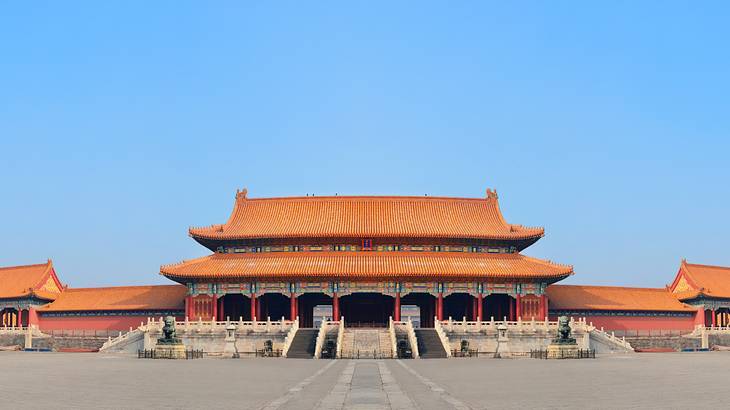 A rectangular structure with red roofs and several stairs going into the building