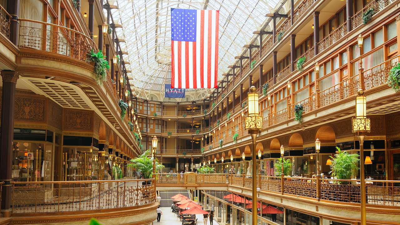 An old-fashioned style mall with balconies and a US flag hanging from a glass roof