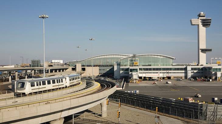 An international airport terminal, a white train and a tall control tower