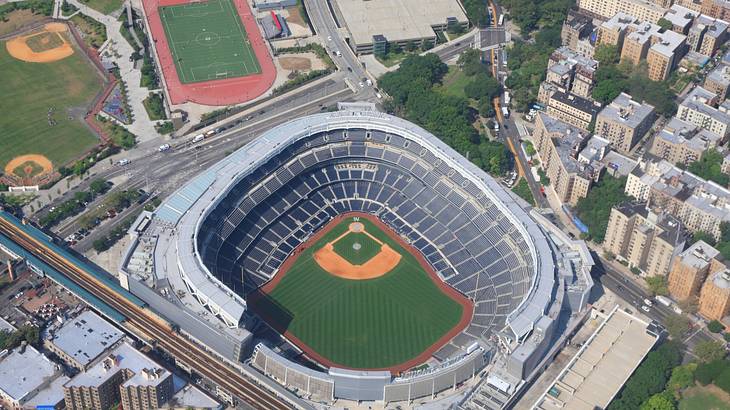 A massive baseball stadium with bleachers and a green field from above A massive baseball stadium with bleachers and a green field from above