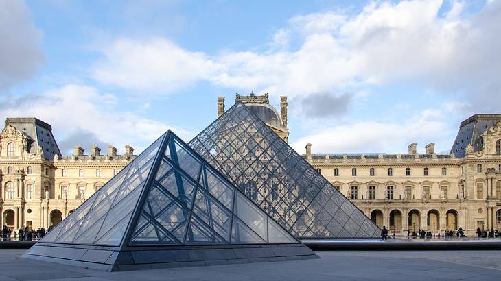 Two stunning glass pyramid exteriors, with a large rectangle building at the back