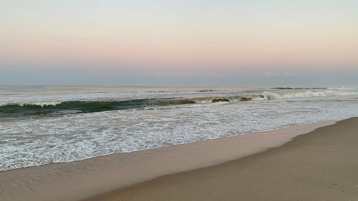Sunset with waves crashing on a sandy beach Sunset with waves crashing on a sandy beach