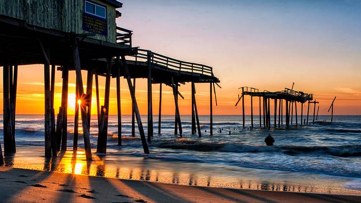 Sunrise over the iconic fragmented Frisco pier, waves and sand