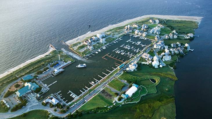 Aerial view of a marina surrounded by water and green grass Aerial view of a marina surrounded by water and green grass