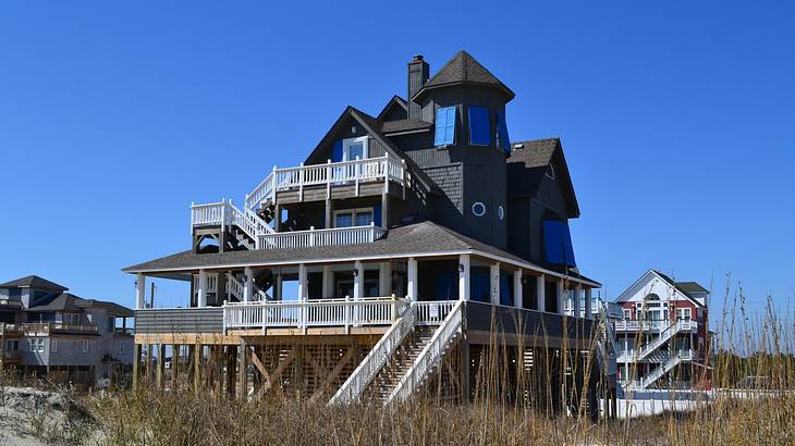 A single-family beach house with clear blue sky above and grass in front