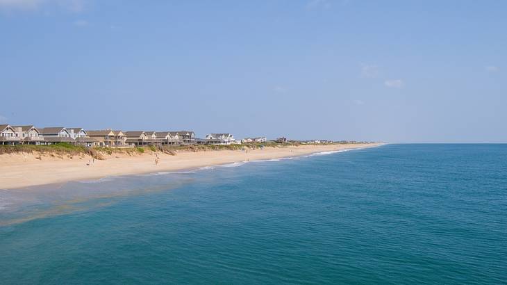 Beach houses in Outer Banks along the coastline facing the sea under a clear sky