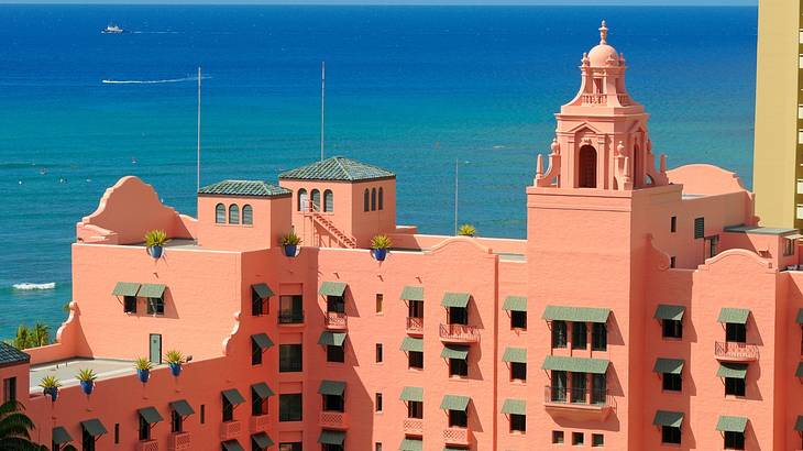 View of a bright pink building with a bright blue ocean in the background